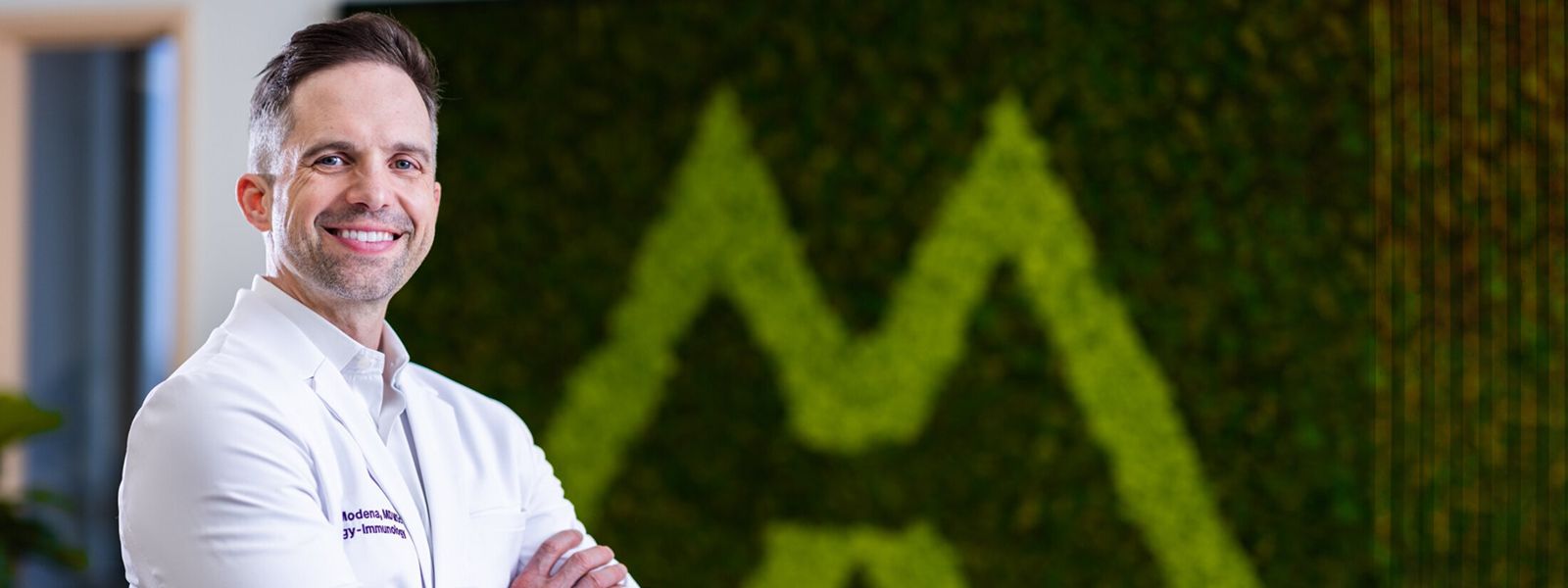Male doctor smiling in a medical office setting.