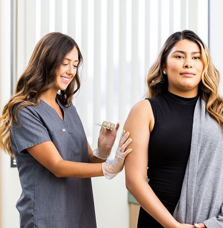 Healthcare professional administering a vaccine to patient.