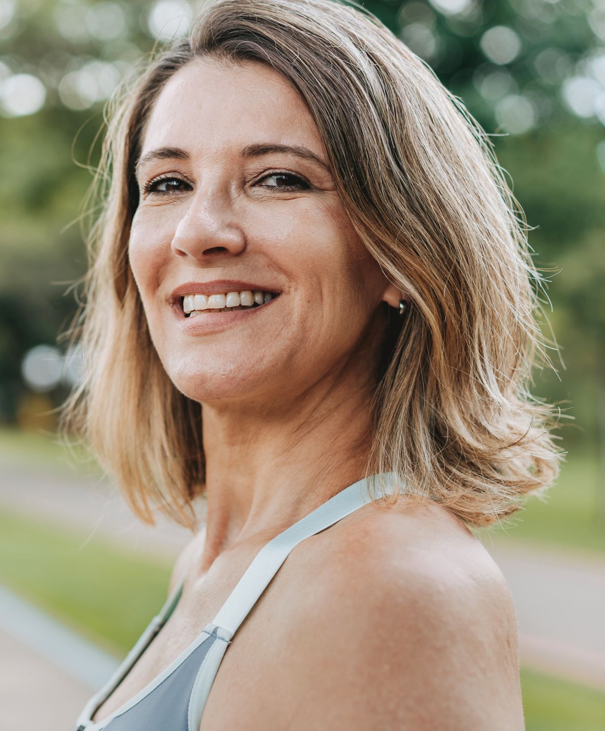 Smiling woman outdoors in athletic attire.