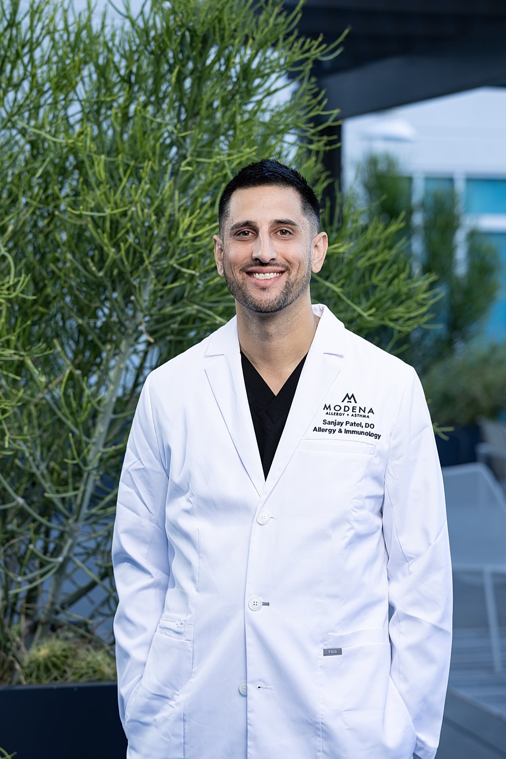 Smiling man in medical white coat portrait.