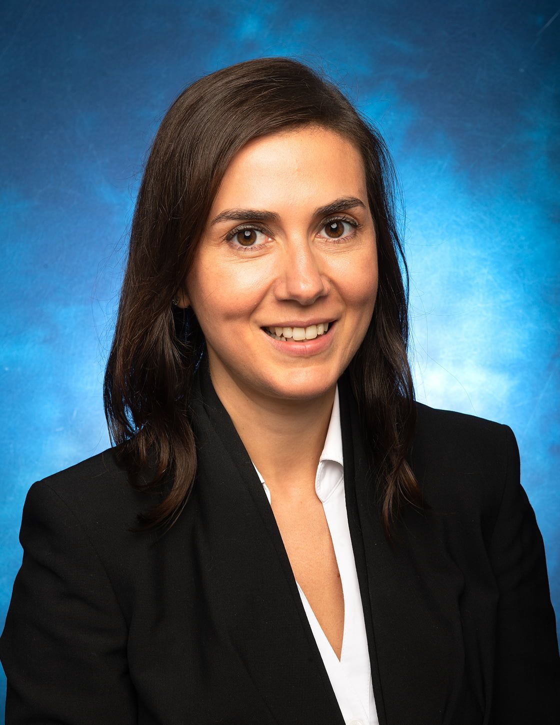 Woman in a black blazer smiling at camera.