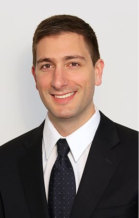 Professional man in suit and tie smiling.